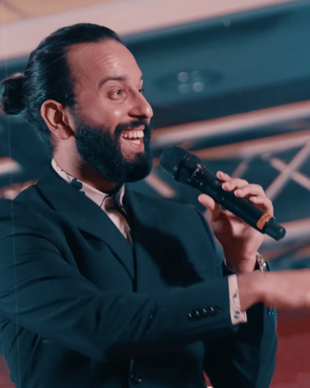 Un cantante riendo frente al micrófono