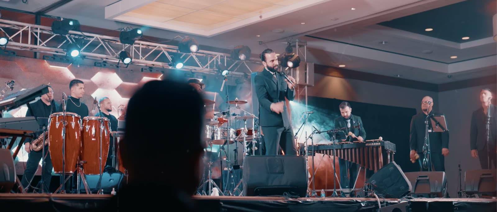 Una orquesta de salsa completa en un escenario iluminado