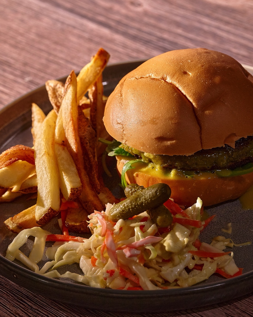 Burger with fries and slaw on a dark plate