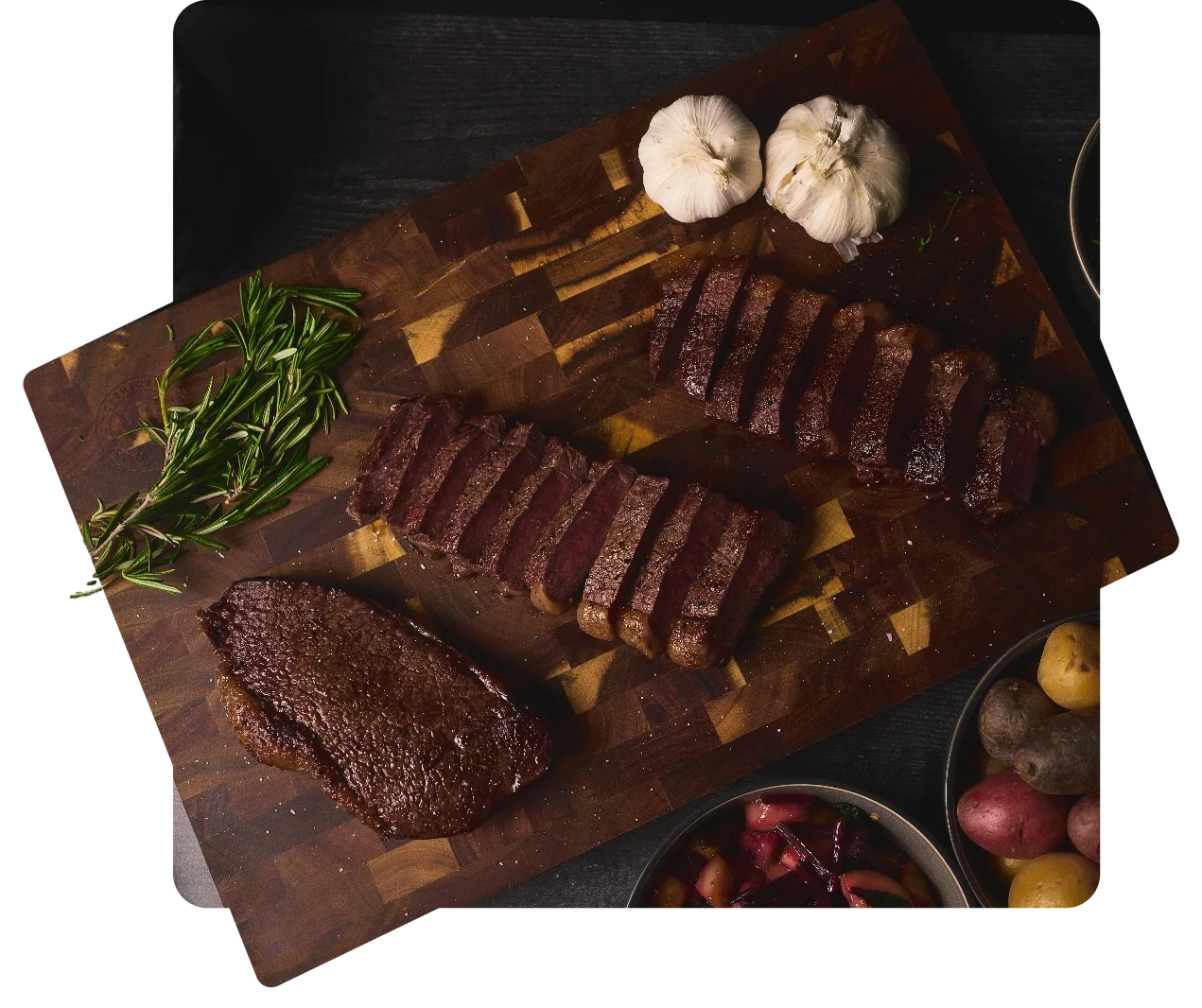 Bistec rebanado con romero y ajo sobre una tabla